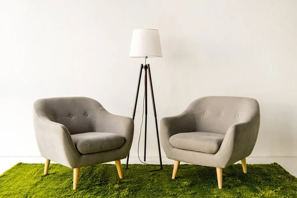 Fauteuils et lampe sur tapis vert — Photo de stock