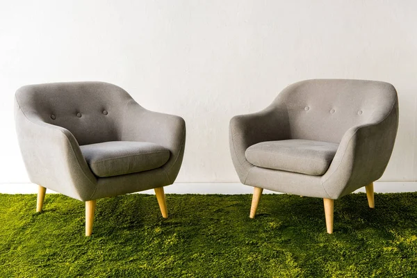 Armchairs on green carpet — Stock Photo