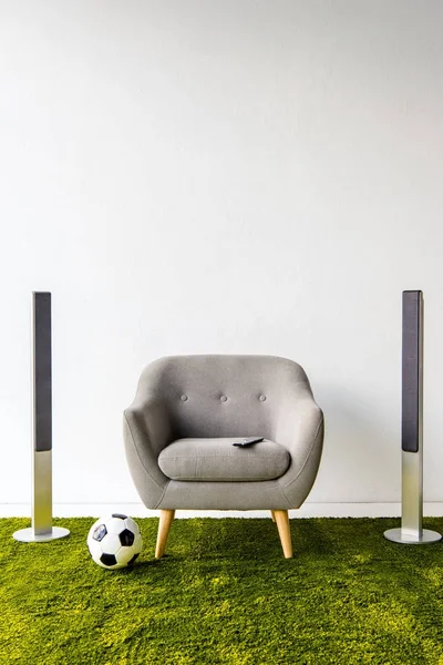 Armchair with remote controller, ball and loudspeakers — Stock Photo