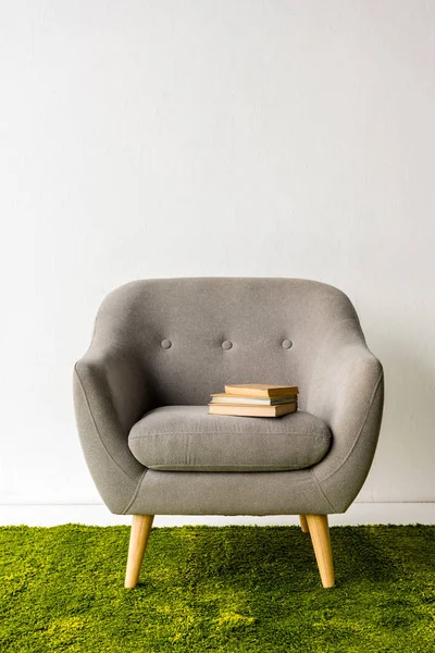 Bücher auf grauem Sessel — Stockfoto