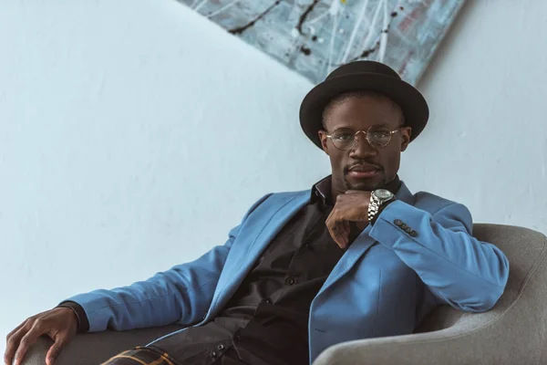 Man in eyeglasses, hat and blue jacket — Stock Photo