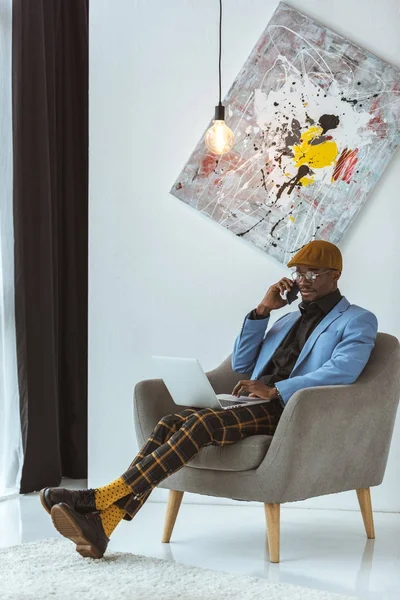 Fashionable businessman with laptop and smartphone — Stock Photo