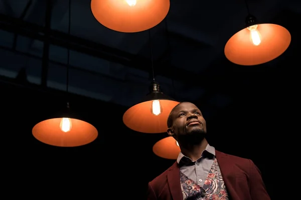 Homme dans la chambre noire avec des lampes — Photo de stock