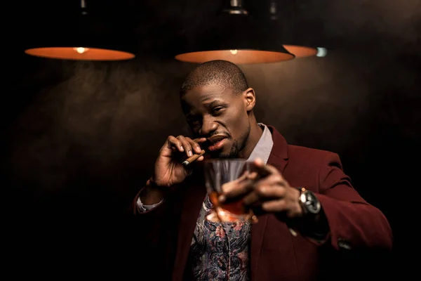 Hombre afroamericano con whisky y cigarro - foto de stock