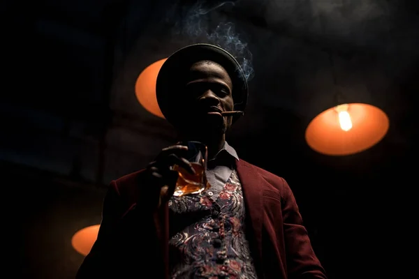 Hombre afroamericano con whisky y cigarro - foto de stock