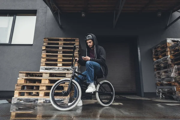 Cycliste bmx utilisant un smartphone — Photo de stock