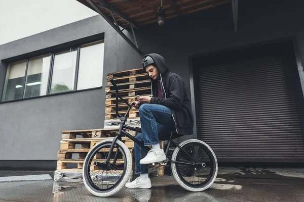 Cycliste bmx utilisant un smartphone — Photo de stock