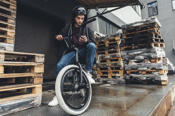 Велосипедист bmx с помощью смартфона — стоковое фото