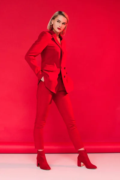 Стильна дівчина позує в червоному костюмі — стокове фото