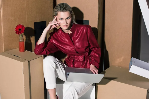 Menina com laptop em caixas de papelão — Fotografia de Stock