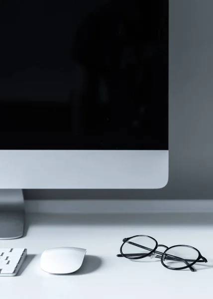 Óculos e mouse de computador na mesa de trabalho — Fotografia de Stock