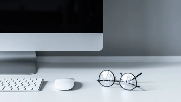 Óculos com reflexão sobre mesa de trabalho branco — Fotografia de Stock