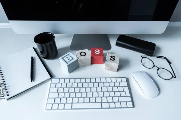 Working table with wooden cubes with word Boss — Stock Photo