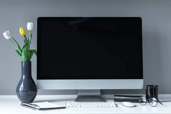 Vaso com tulipas na mesa de trabalho branca — Fotografia de Stock