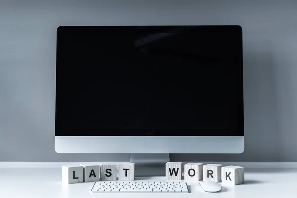 Computer and wooden cubes with words Last Work — Stock Photo