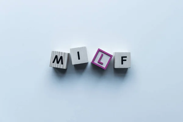 Top view of wooden cubes with word Milf on blue tabletop — Stock Photo