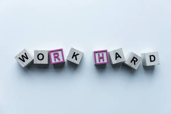 Top view of wooden cubes with words Work Hard on blue surface — Stock Photo