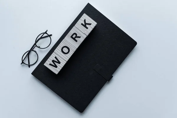 Vista superior de cuaderno negro y cubos con palabra Trabajo — Stock Photo