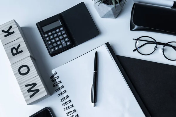 Overhead view of working table with notebook and pen — Stock Photo