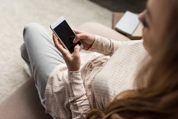 Високий кут зору молодої жінки, використовуючи смартфон на дивані вдома — стокове фото