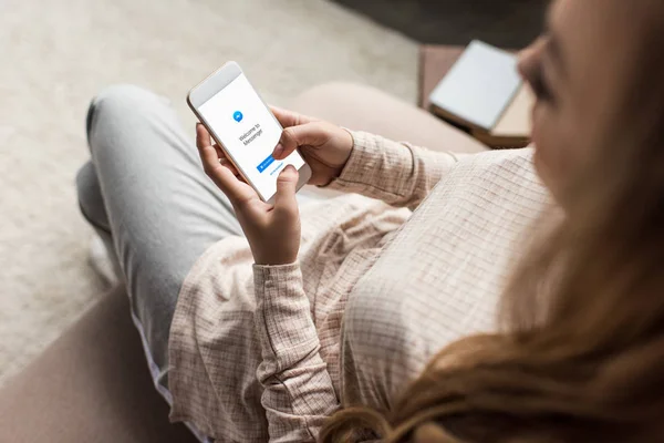 Schnappschuss von Frau auf Couch mit Smartphone und Messenger-App auf dem Bildschirm — Stockfoto