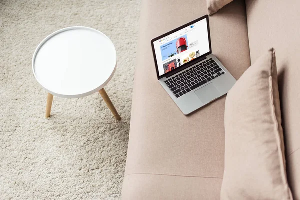 Visão de alto ângulo do laptop em pé no sofá acolhedor com site do ebay na tela — Fotografia de Stock