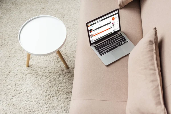 Blick auf den Laptop auf der gemütlichen Couch mit Soundcloud-Webseite auf dem Bildschirm — Stockfoto