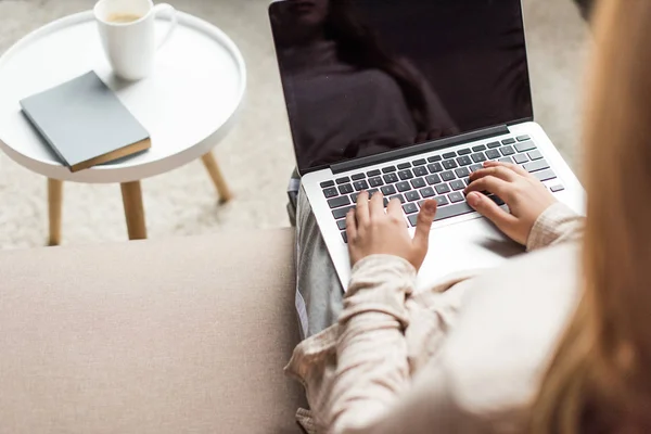 Tiro cortado de mulher jovem trabalhando com laptop no sofá — Fotografia de Stock