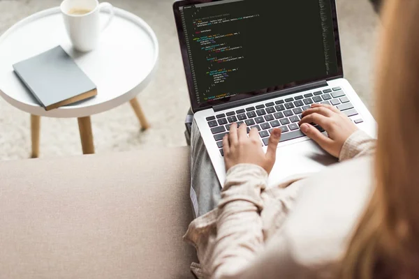 Cropped shot of young female developer coding with laptop at home — Stock Photo