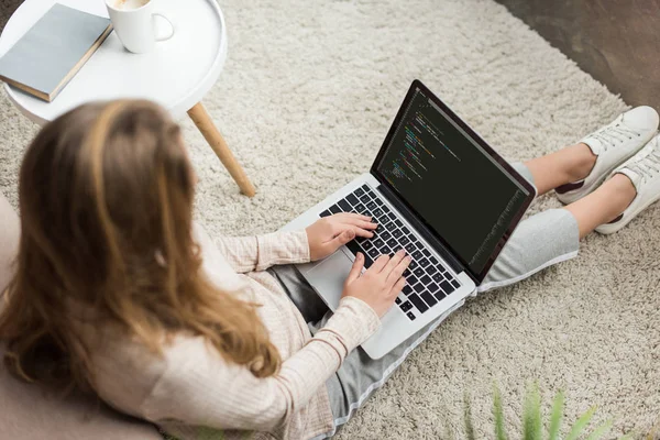 Vista ad alto angolo di giovane codifica sviluppatore femminile con computer portatile a casa — Foto stock