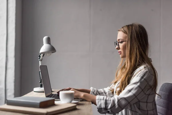 Visão lateral da jovem empresária focada trabalhando com laptop — Fotografia de Stock