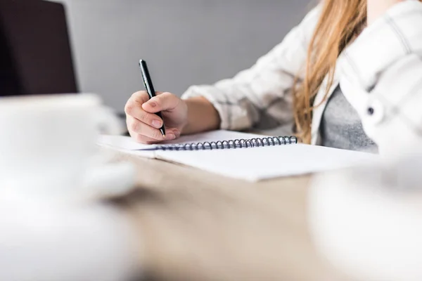 Tiro recortado de estudante escrevendo menina no caderno — Fotografia de Stock