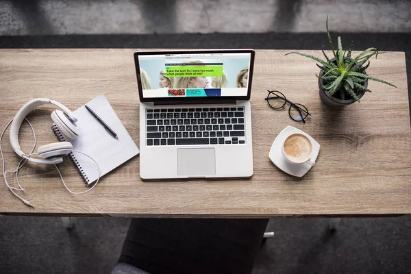 Top view of laptop standing at modern workplace with bbc website on screen — Stock Photo