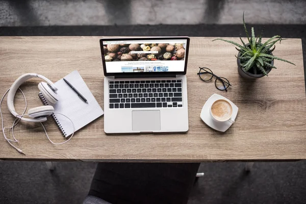 Верхний вид ноутбука, стоящего на современном рабочем месте с Shutterstock веб-сайт на экране — стоковое фото