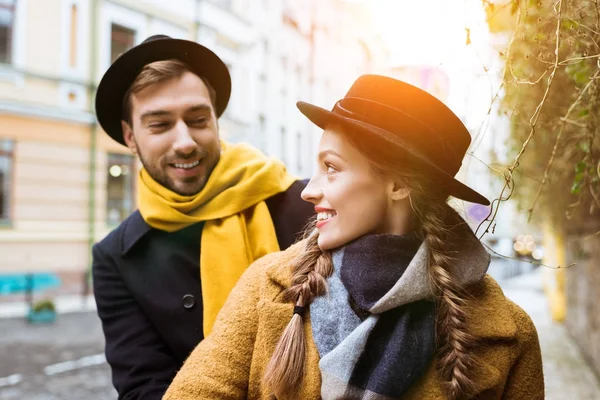 Joven feliz pareja en otoño traje mirando el uno al otro - foto de stock