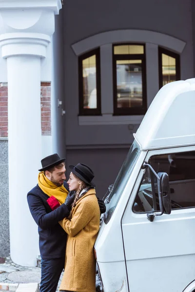 Schönes junges Paar umarmt sich im Herbst-Outfit neben Auto — Stockfoto