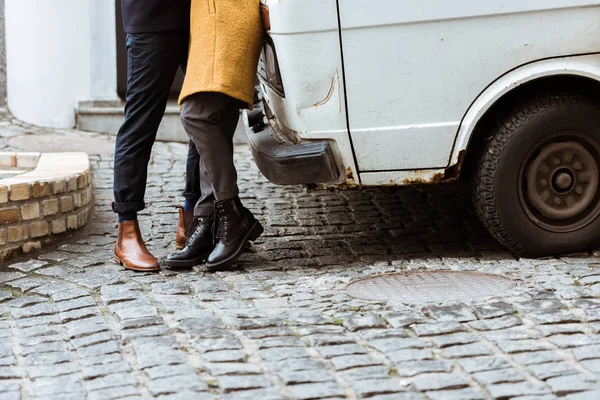 Immagine ritagliata di coppia in abito autunno abbracciare accanto alla macchina — Foto stock