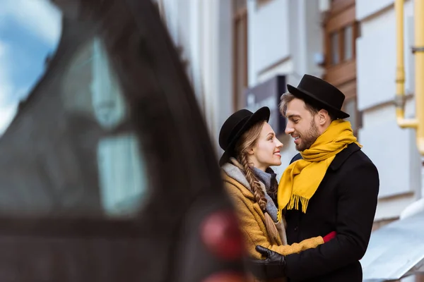 Junges attraktives Paar umarmt sich hinter Auto — Stockfoto