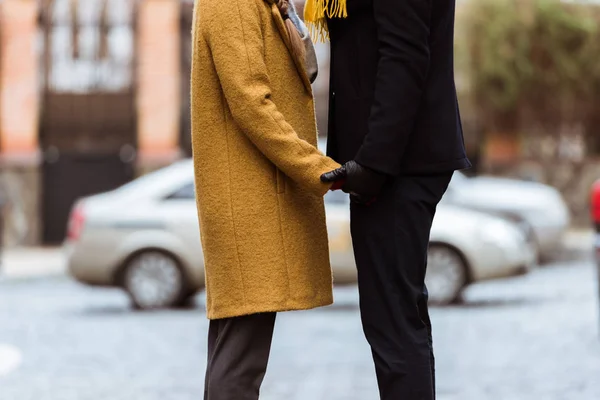 Imagen recortada de las manos de la pareja en traje de otoño - foto de stock