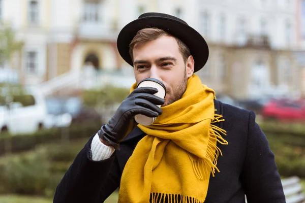 Hombre guapo en traje de otoño beber café en el banco - foto de stock