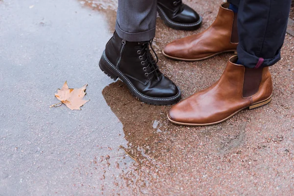 Imagen recortada de piernas femeninas y masculinas en zapatos de otoño - foto de stock