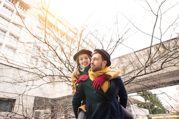 Bonito homem dando piggyback passeio para feliz namorada — Fotografia de Stock