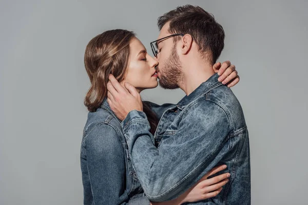 Sedutor jovem casal apaixonado beijando isolado no cinza — Fotografia de Stock