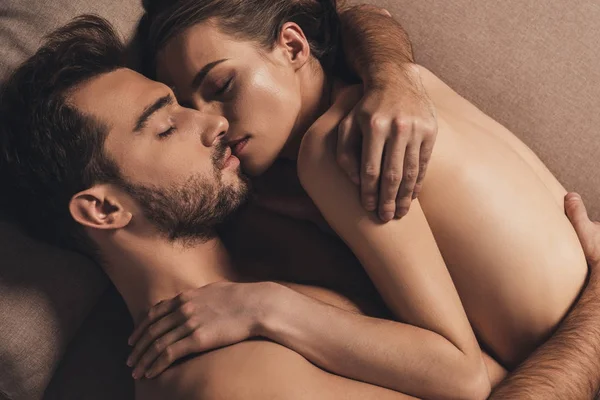 Чуттєва гола молода пара обіймає і спить разом у ліжку — стокове фото