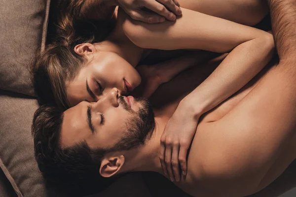 Hermosa sexy joven pareja abrazando y durmiendo juntos en la cama - foto de stock