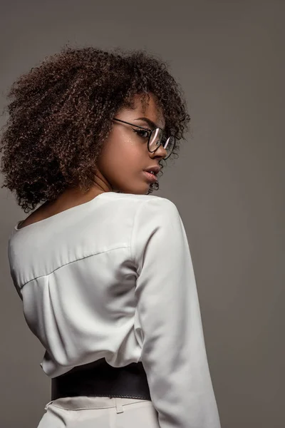 Стильная африканская американка в белой рубашке в очках, изолированных на сером фоне — стоковое фото