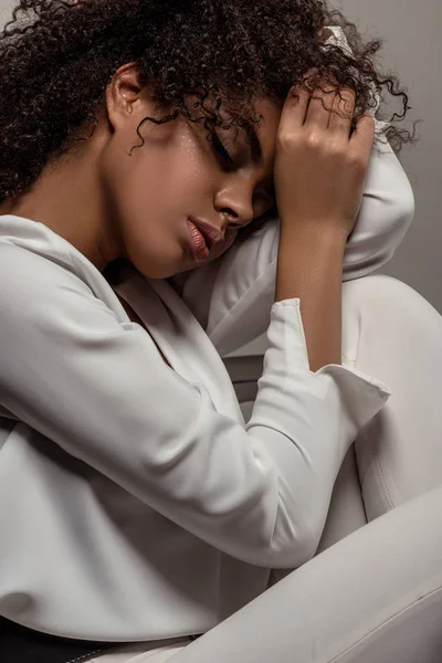 Young sensual african american woman in white shirt dreaming isolated on grey background — Stock Photo