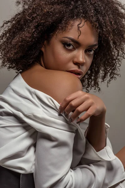 Jovem mulher americana africana sensual em camisa branca olhando para a câmera isolada em fundo cinza — Fotografia de Stock