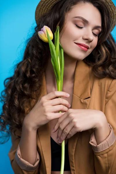 Hermosa mujer joven en sombrero canotier y chaqueta con flor de tulipán - foto de stock