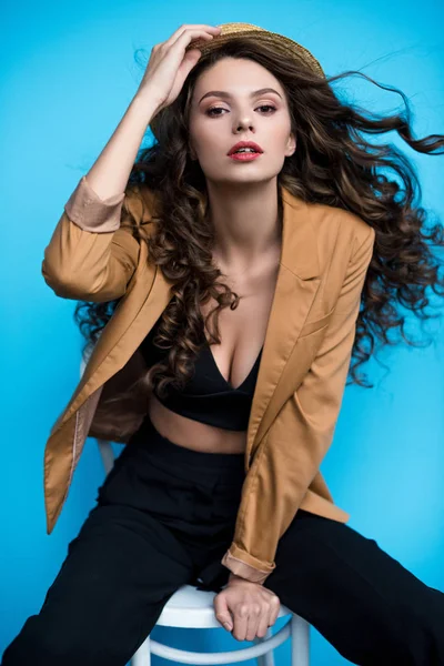 Hermosa joven con el pelo largo ondeando por el viento en sombrero canotier y chaqueta — Stock Photo